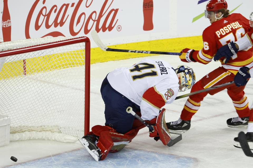 Calgary Flames center Martin Pospisil, right, scores against Florida Panthers goalie Anthony Stolarz during the first period of an NHL hockey game in Calgary, Alberta., Monday, Dec. 18, 2023. (Larry MacDougal/The Canadian Press via AP)