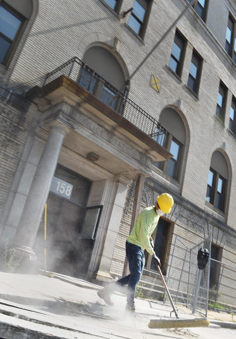 A worker sweeps dust and debris at the former Fall River Police Station on Bedford Street in this file photo.