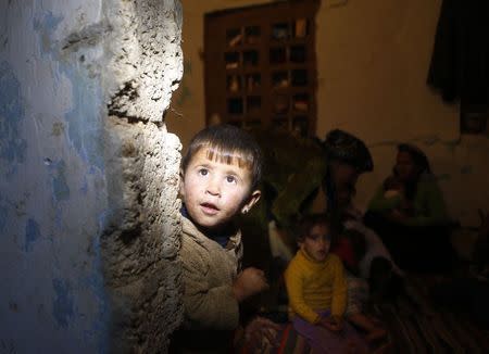 A Kurdish refugee boy from the Syrian town of Kobani looks out from a small room where he lives with his family in the southeastern town of Suruc, Sanliurfa province, October 13, 2014. REUTERS/Umit Bektas