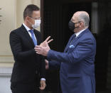 Poland's Foreign Minister Zbigniew Rau, right, walks with Hungarian Foreign Minister Peter Szijjarto during a meeting of foreign ministers from four central European countries known as the Visegrad Four in Lodz, Poland, Friday, May 14, 2021.(AP Photo/Czarek Sokolowski)