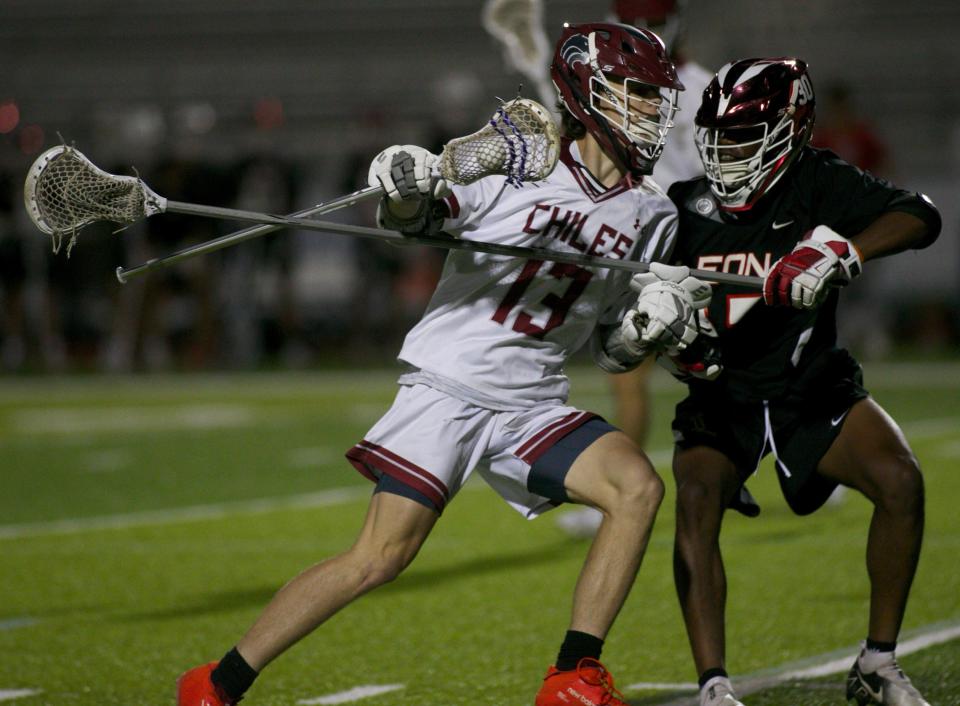 Chiles junior attacker Casey Broccan (13) battles a Leon defender in a game against Leon on April 12, 2022, at Chiles High School. The Timberwolves won 9-6.