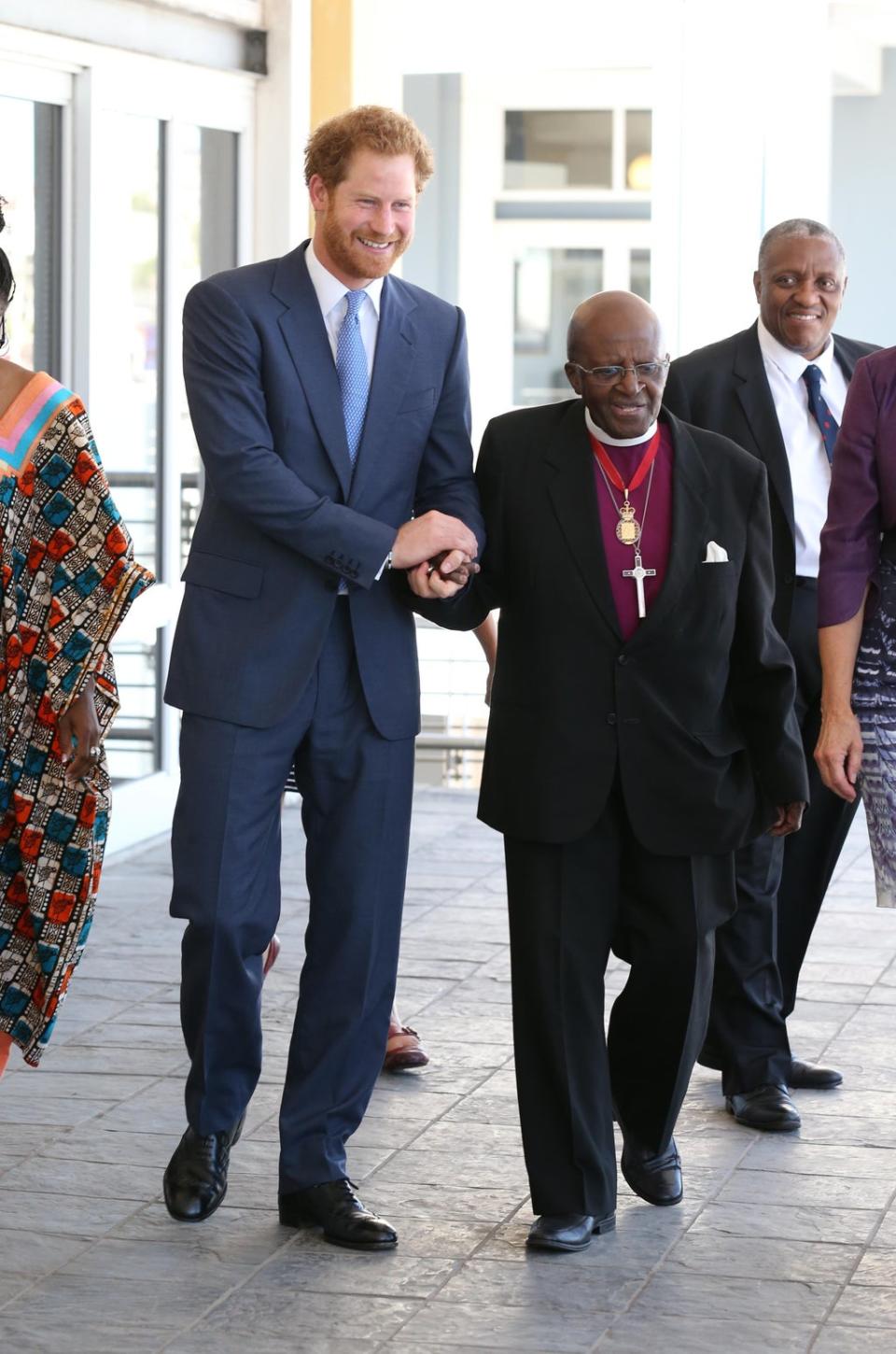 Prince Harry holding hands with the Archbishop Emeritus Desmond Tutu in 2015 (Chris Radburn/PA)