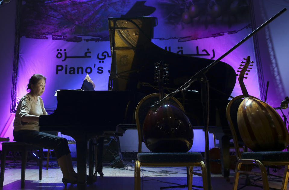 Japanese pianist Kaoru Imahigashi plays the piano during a concert to mark the debut of Gaza's only grand piano after it was rescued from conflict, at a theater nestled in the Palestinian Red Crescent Society's building in Gaza City, Sunday, Nov. 25, 2018. The only grand piano in the Gaza Strip is debuting to the public for the first time in over a decade after its restoration. (AP Photo/Adel Hana)