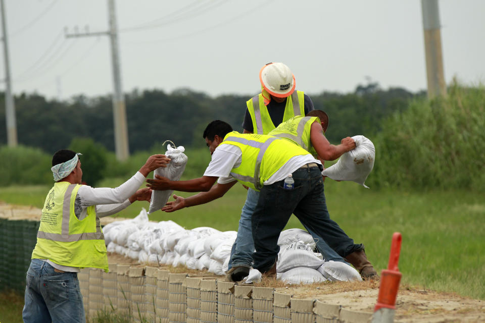 Workers stack sandbags on top of retaining wall baskets in preparation for Tropical Storm Isaac, which is expected to make landfall on the Louisiana coast as a hurricane, in Port Sulphur, La., Monday, Aug. 27, 2012. (AP Photo/Gerald Herbert)