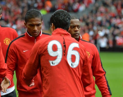 Liverpool's Uruguayan striker Luis Suarez (2nd R) shakes hands with Manchester United's Senegalese-born French defender Patrice Evra (R) and Ecuadorian midfielder Antonio Valencia (L) before the English Premier League football match between Liverpool and Manchester United at Anfield in Liverpool. United won 2-1