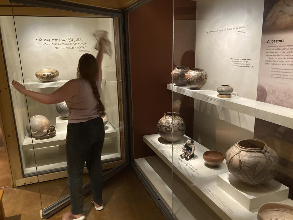 Finishing touches are made on a community-curated exhibition of Native American pottery from the Pueblo Indian region of the U.S. Southwest on July 28, 2022, at the Museum of Indian Arts and Culture in Santa Fe, N.M. Native American artists, political leaders and storytellers picked their favorite ceramic pieces from institutional collections that didn't always defer to Indigenous perspectives. Showings also are scheduled at the Metropolitan Museum of Art in New York and museums in Houston and St. Louis. (AP Photo/Morgan Lee)