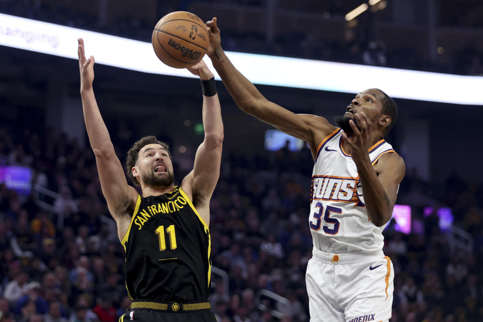 Phoenix Suns forward Kevin Durant (35) defends against Golden State Warriors guard Klay Thompson (11) during the first half of an NBA basketball game in San Francisco, Saturday, Feb. 10, 2024. (AP Photo/Jed Jacobsohn)