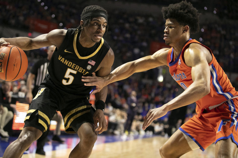 Vanderbilt guard Ezra Manjon (5) drives against Florida guard Zyon Pullin (0) during the first half of an NCAA college basketball game, Saturday, Feb. 24, 2024, in Gainesville, Fla. (AP Photo/Alan Youngblood)