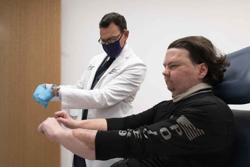 Dr. Eduardo Rodriguez has Joe DiMeo demonstrate the flexibility in his new hands, Monday, Jan. 25, 2021 at NYU Langone Health in New York. Rodriguez led a surgical team that amputated both of DiMeo’s hands, replacing them mid-forearm and connecting nerves, blood vessels and 21 tendons with hair-thin sutures. (AP Photo/Mark Lennihan)