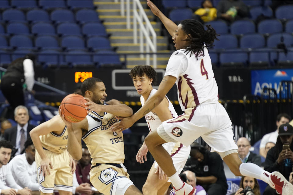 Georgia Tech guard Kyle Sturdivant (1) looks to shoot as Florida State guard Caleb Mills (4) defends during the first half of an NCAA college basketball game at the Atlantic Coast Conference Tournament in Greensboro, N.C., Tuesday, March 7, 2023. (AP Photo/Chuck Burton)