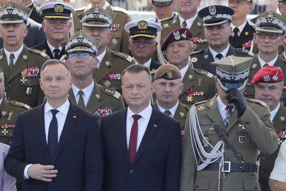 Poland's President Andrzej Duda, left, and Defense Minister Mariusz Blaszczak, center, with military commanders watch a military parade on Polish Army Day in Warsaw, Poland, on Aug. 15, 2023. Present are Chief of the General Staff at the time, Gen. Rajmund Andrzejczak, left, and army operational commander at the time, Gen. Tomasz Piotrowski, in glasses, behind Duda. Both officers resigned over a spat with Blaszczak and were replaced on Tuesday, 10 October 2023. The new operational commander, Gen. Maciej Klisz is seen between Duda and Andrzejczak. (AP Photo/Czarek Sokolowski)