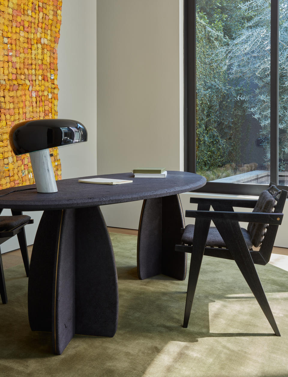 home office with dark oval desk and angular mid-century chair