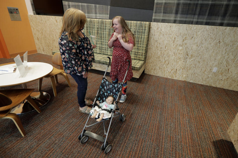 Connie Wade, left, talks with her daughter Emilyanne, 12, Wednesday, June 17, 2020, in the lobby area of Mary's Place, a family homeless shelter located inside an Amazon corporate building on the tech giant's Seattle campus. The facility is home to the Popsicle Place shelter program, an initiative to address the needs of homeless children with life-threatening health conditions. (AP Photo/Ted S. Warren)