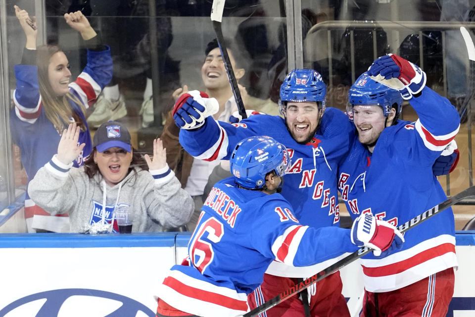 New York Rangers left wing Alexis Lafreniere (13) celebrates with center Vincent Trocheck (16) and defenseman Erik Gustafsson (56) after scoring the winning goal during overtime of an NHL hockey game against the Colorado Avalanche, Monday, Feb. 5, 2024, at Madison Square Garden in New York. (AP Photo/Mary Altaffer)