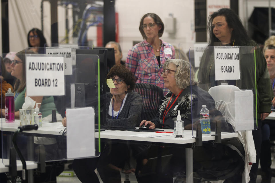 Republican and Democratic election workers on the adjudication board decide about problematic ballots at the Maricopa County Tabulations Election Center on Nov. 10, 2022, in Phoenix.