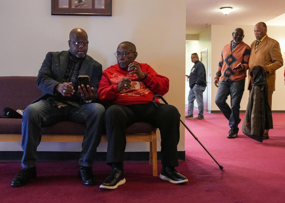 Minster Harambee Purnell (left) sits with paster Tom Glenn as his brother James King (right) greets friends during Sunday service on Sunday, March 19, 2023 at Emmanuel Christian Fellowship Center in Indianapolis. 