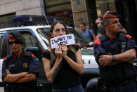 <p>A protestor holds up a sign in front of a Catalan police outside the Catalan region’s foreign affairs ministry building during a raid by Spanish police on government offices, in Barcelona, Spain, Sept. 20, 2017. (Photo: Susana Vera/Reuters) </p>