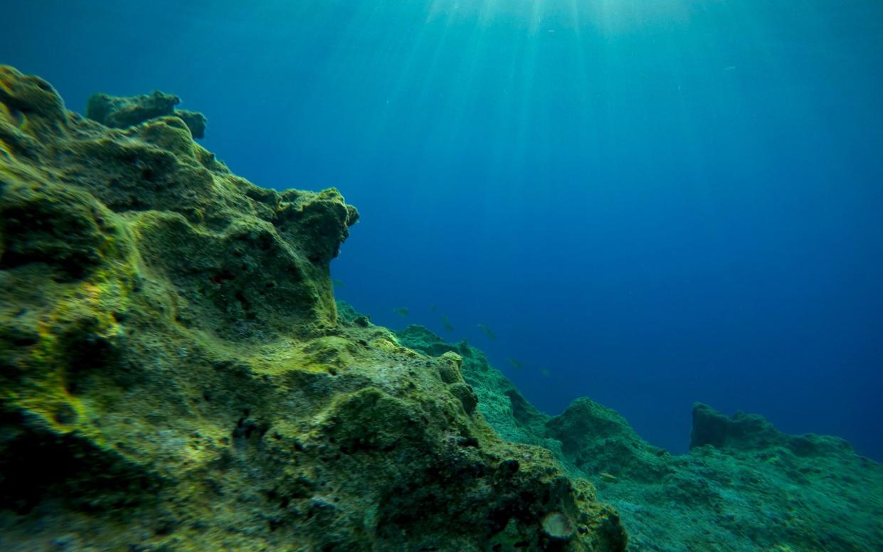 Rays of sunlight shining into sea, underwater view