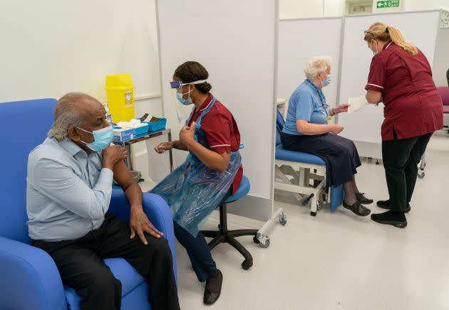 Care home worker Pillay Jagambrun (left), 61, receives the Pfizer-BioNTech Covid-19 vaccine in The Vaccination Hub at Croydon University Hospital, south London on Tuesday 