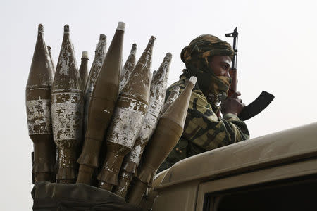 A Chadian soldier rides atop a pickup truck next to a bag of rocket-propelled grenades in Gambaru, Nigeria, February 26, 2015. REUTERS/Emmanuel Braun