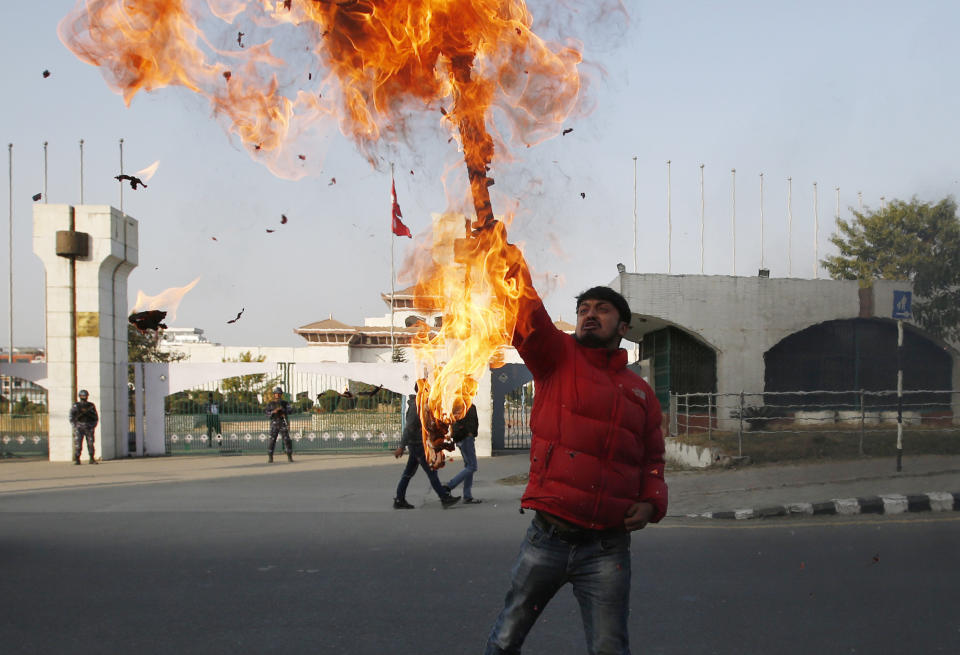 A Nepalese protester burns an effigy of prime minister Khadga Prasad Oli in front of the parliament building in Kathmandu, Nepal, Sunday, Dec. 20, 2020. Nepal’s president dissolved Parliament on Sunday after the prime minister recommended the move amid an escalating feud within his Communist Party that is likely to push the Himalayan nation into a political crisis. Parliamentary elections will be held on April 30 and May 10, according to a statement from President Bidya Devi Bhandari's office. (AP Photo/Niranjan Shrestha)