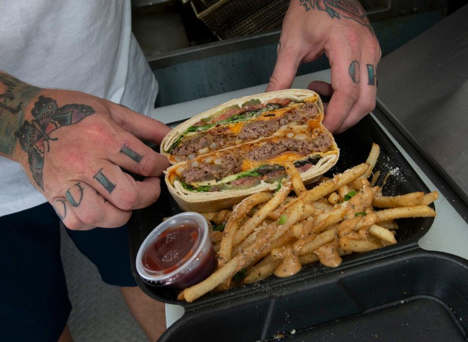 Chef Rusty Strain shows off a signature menu item on the Rustyc Spoon food truck on Wednesday, Sept. 20, 2023. Strain is returning to fine dining in October when he opens a new restaurant at the Marcus Pointe Golf Club.