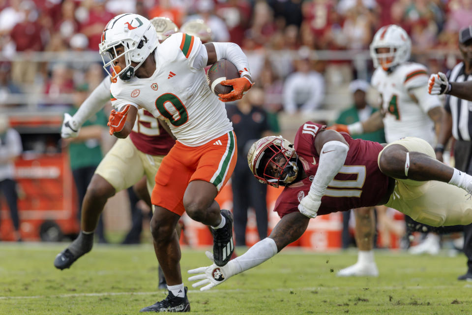 Miami wide receiver Brashard Smith (0) eludes Florida State linebacker DJ Lundy (10) during the first half of an NCAA college football game, Saturday, Nov. 11, 2023, in Tallahassee, Fla. (AP Photo/Colin Hackley)