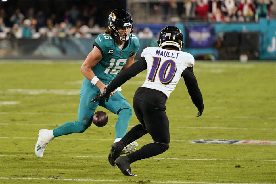 Jacksonville Jaguars quarterback Trevor Lawrence (16) fumbles the ball as Baltimore Ravens cornerback Arthur Maulet (10) closes in during the first half of an NFL football game Sunday, Dec. 17, 2023, in Jacksonville, Fla. Maulet recovered the ball on the play. (AP Photo/John Raoux)