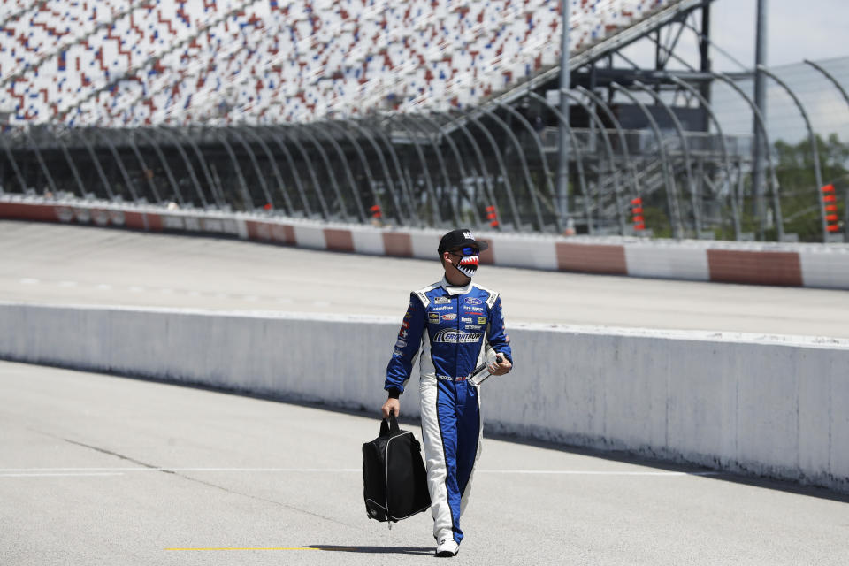 Driver Michael McDowell walks to his car before the start of the NASCAR Cup Series auto race Sunday, May 17, 2020, in Darlington, S.C. (AP Photo/Brynn Anderson)