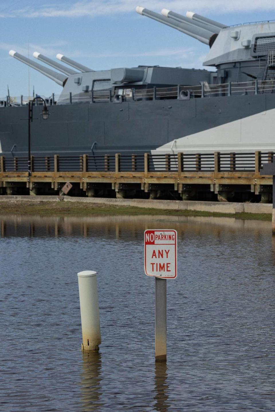 A sign stands in floodwaters in the parking lot of the USS North Carolina National Historic Site.
