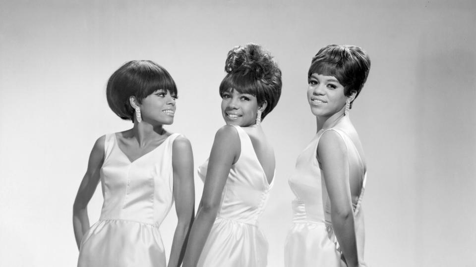the supremes pose for a photo in matching white sleeveless dresses