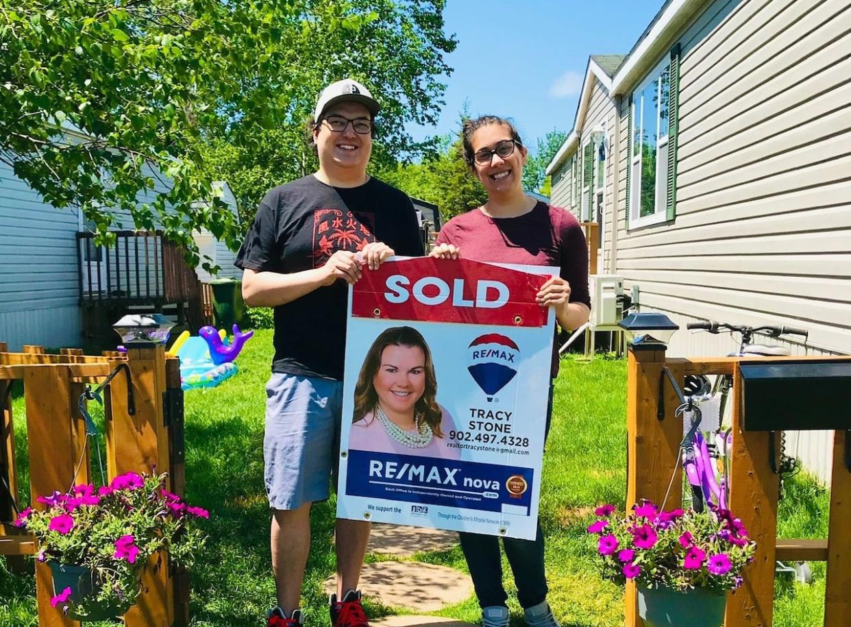 Taylor Forrest, right, and her partner pose in front of their home in the Springfield Estates mobile-home park in Middle Sackville when they moved in 2020. (Taylor Forrest - image credit)