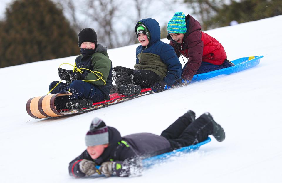 Kids and adults sled down the hill in 2021 at Buttermilk Creek Park.