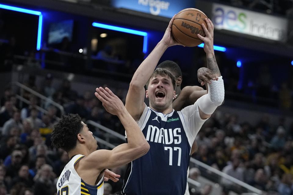 Dallas Mavericks' Luka Doncic (77) slooks to shoot against Indiana Pacers' Ben Sheppard, left, during the first half of an NBA basketball game, Sunday, Feb. 25, 2024, in Indianapolis. (AP Photo/Darron Cummings)