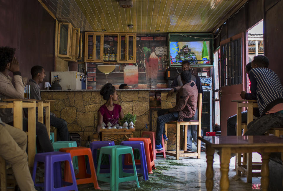 Ethiopians follow the news on television at a cafe in Addis Ababa, Ethiopia Sunday, June 23, 2019. Ethiopia's government foiled a coup attempt in a region north of the capital and the country's military chief was shot dead, the prime minister Abiy Ahmed said Sunday in a TV announcement. (AP Photo/Mulugeta Ayene)