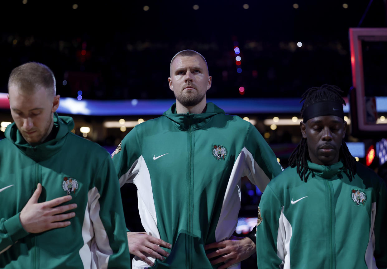 Boston, MA - June 9: Boston Celtics center Kristaps Porzingis, middle, stands during the national anthem with forward Sam Hauser, left, and guard Jrue Holiday before Game 2 of the 2024 NBA Finals. (Photo by Danielle Parhizkaran/The Boston Globe via Getty Images)