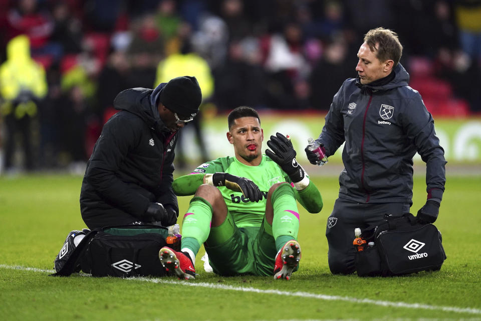 West Ham United goalkeeper Alphonse Areola receives treatment for an injury to the face after a challenge with Sheffield United's Oli McBurnie, during the English Premier League soccer match between Sheffield United and West Ham United at Bramall Lane, in Sheffield, England, Sunday, Jan. 21, 2024. (Nick Potts/PA via AP)