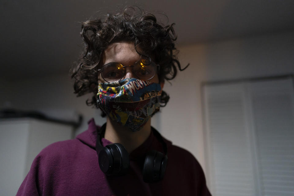 Fabian Swain wears a Wolverine face mask in his Germantown, Md., home, Monday, Nov. 14, 2022. Fabian and his mother, Carey Johnson, have recovered from COVID. (AP Photo/Carolyn Kaster)