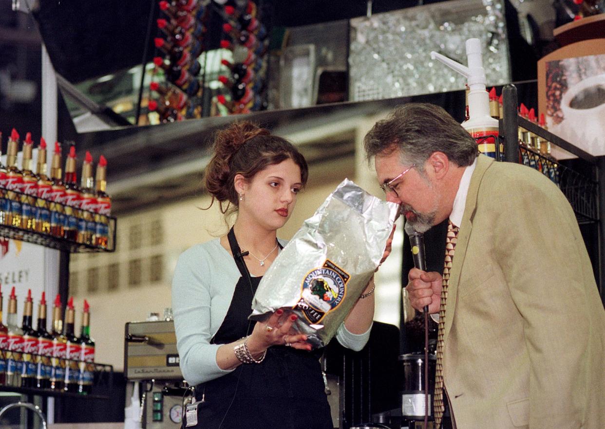 Christina Gibbs, left, of Saginaw, Michigan, holds up the brand of coffee she was using to make espresso, as Paul Songer, one of the judges, sniffs the beans, during the Torani 5th Annual Barista Cup, Saturday, May 1, 1999, in Philadelphia. Gibbs was named second runner up in the competition, Monday, May 3, 1999. (Photo by William Thomas Cain)