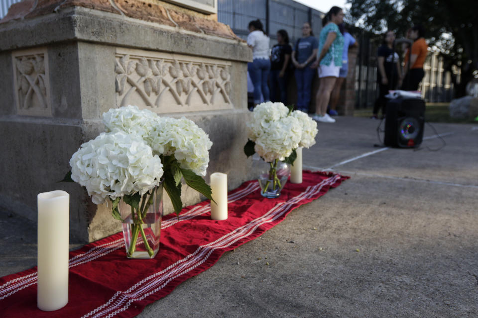 An altar of candles and white hydrangea flowers stands in memoriam of the 22 victims of the recent El Paso shooting during a vigil Sunday, Aug. 11, 2019, at Alice Wilson Hope Park in Brownsville, Texas.(Denise Cathey/The Brownsville Herald via AP)