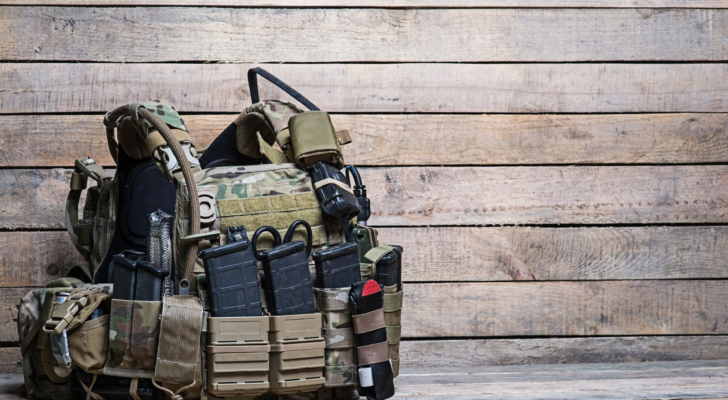 Military body armor,ammunition and ammo,radio and first aid tourniquet.On wooden table/Army bulletproof vest, defense stocks