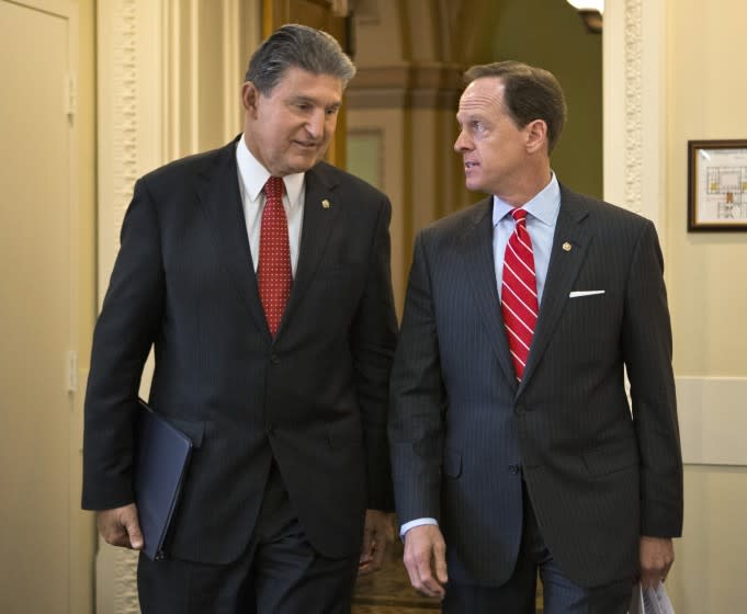 Sen. Joe Manchin, D-W.Va. and Sen. Patrick Toomey, R-Pa. arrive for a news conference on Capitol Hill