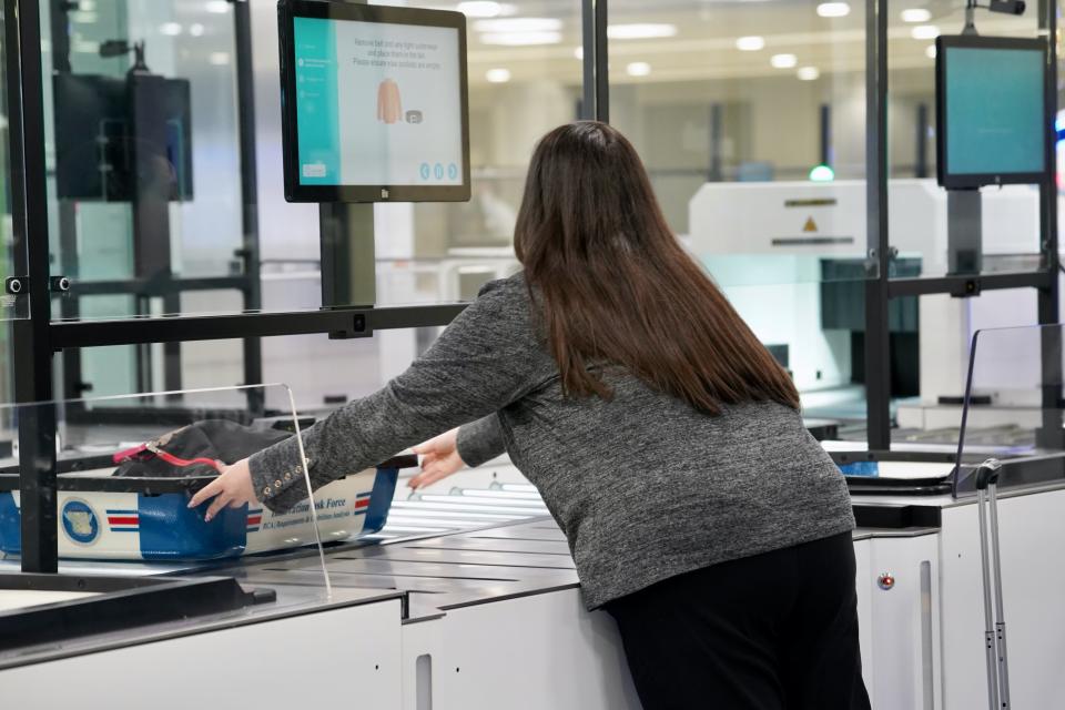 Woman sliding basket at TSA self-service line