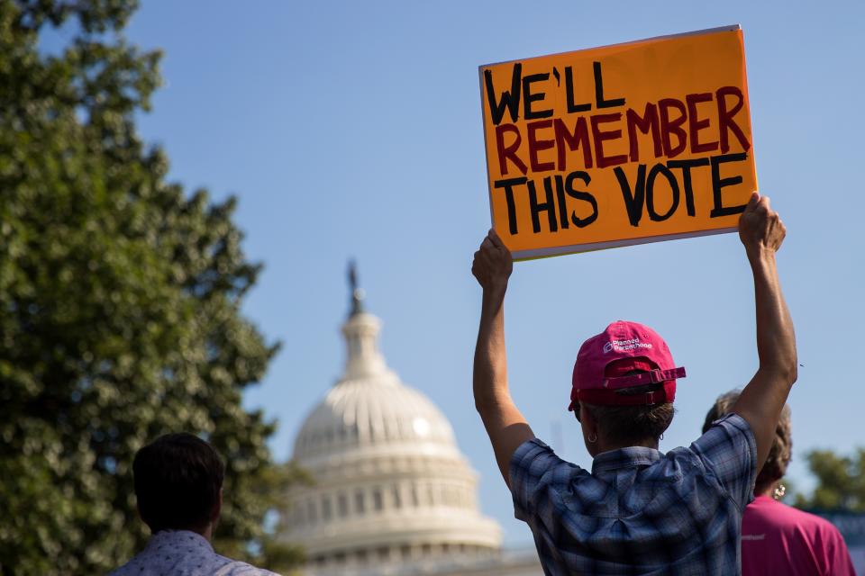 A protester holds up a sign during a rally against the GOP health care plan, on Capitol Hill, July 26, 2017 in Washington, DC. Photo by Drew Angerer/Getty Images