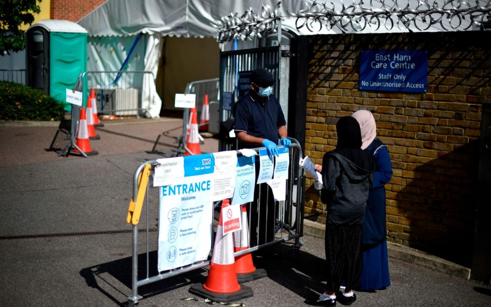 People queue to enter a testing centre in East London - Daniel Leal-Olivas/AFP