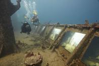 Un par de buzos recorre la exhibición "The Sinking World" en el naufragado barco "SS Stavornikita", en las aguas de Barbados, en el mar Caribe.