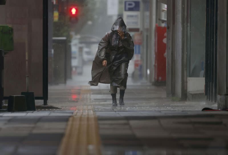 A passerby walks amid heavy rain and wind caused by Typhoon Khanun in Kagoshima, Japan