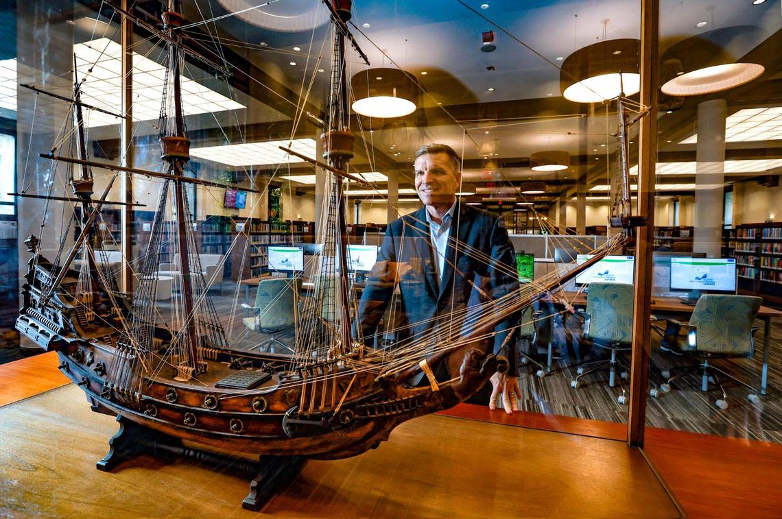 Miami-Dade Public Library System Director Ray Baker looks over the 1930 model of a 17th century Spanish Galleon at Coral Gables Branch Library. The model sits on the table city founder George Merrick originated the plans for the development of the City of Coral Gables. The library plans to reopen on Monday, May 22 after closing for renovations in 2021 with all new lighting, computers, and furnishings. Al Diaz/adiaz@miamiherald.com