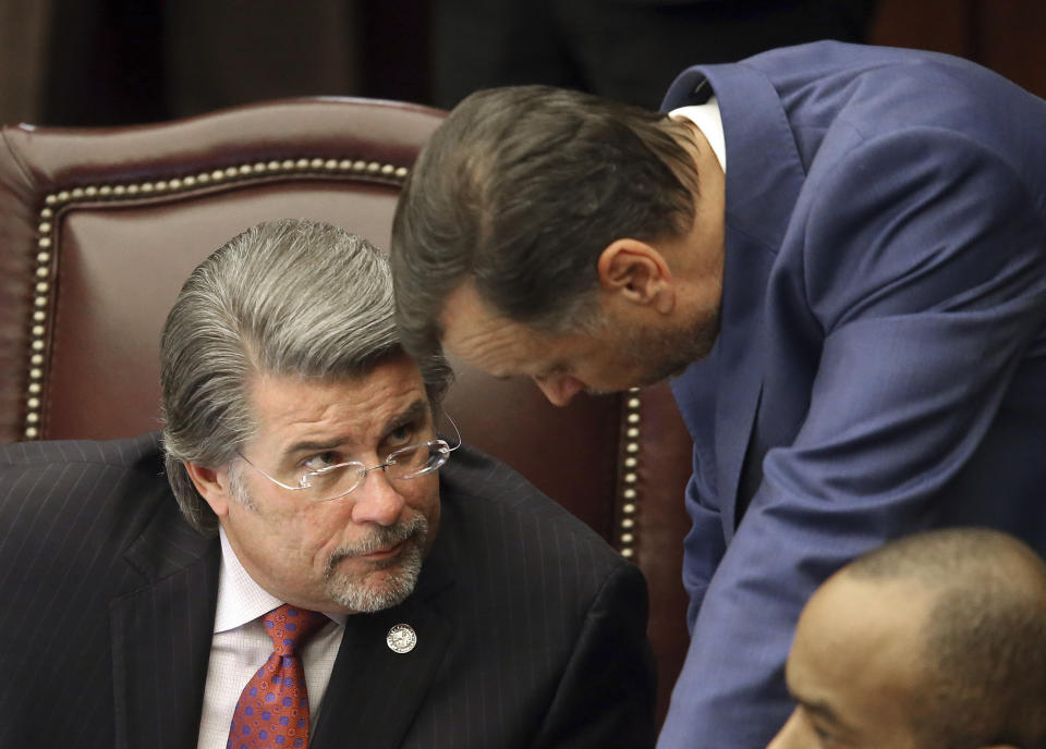 Sen. Gary Farmer, D-Fort Lauderdale, left, confers with Sen. Tom Lee, R-Brandon during a senate special session concerning Gov. Ron DeSantis dismissal of Broward county sheriff Scott Israel on Wednesday Oct. 23, 2019, in Tallahassee, Fla. The Florida Senate handed a political victory to Gov. Ron DeSantis on Wednesday, as the chamber backed the suspension of a county sheriff who the Republican governor said bungled the response to last year's mass shooting in Parkland that killed 17 people. (AP Photo/Steve Cannon)