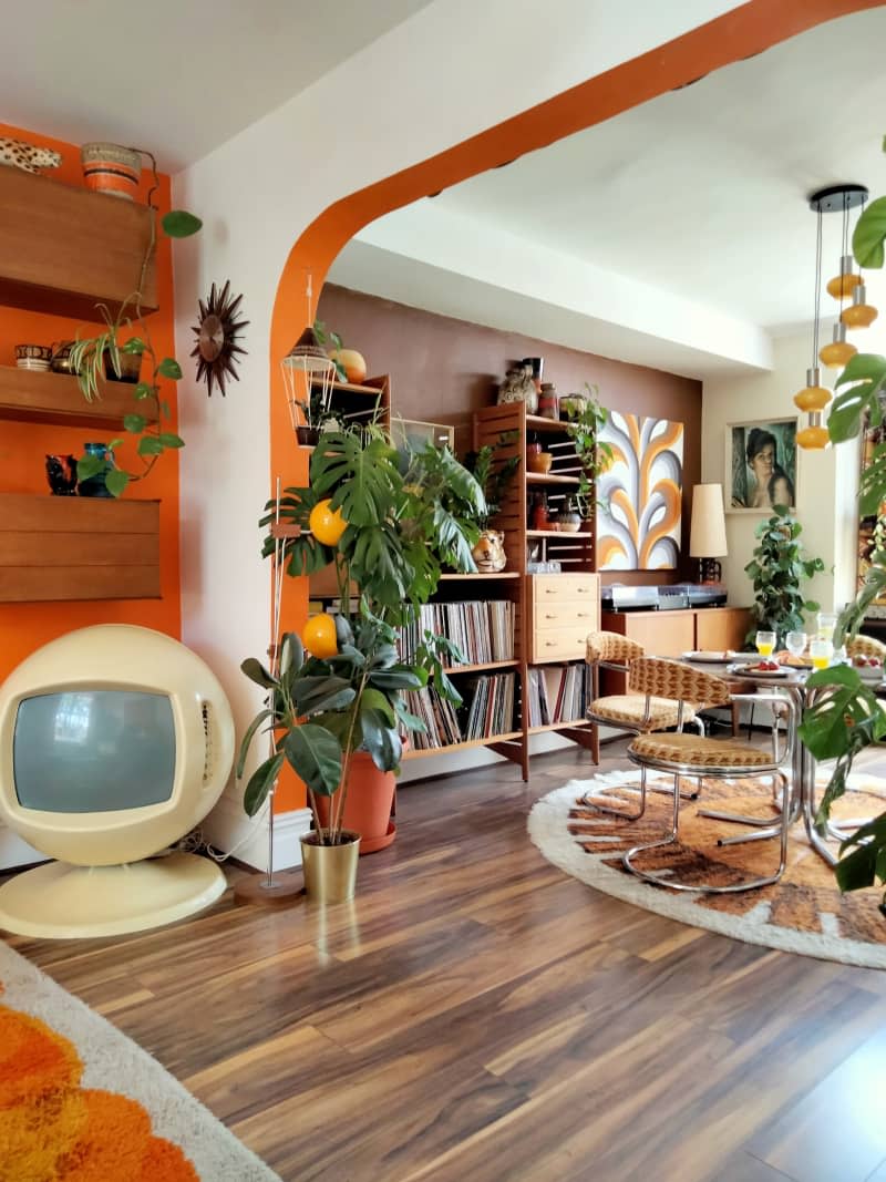 Decorated living room with orange and brown wall and large record collection.